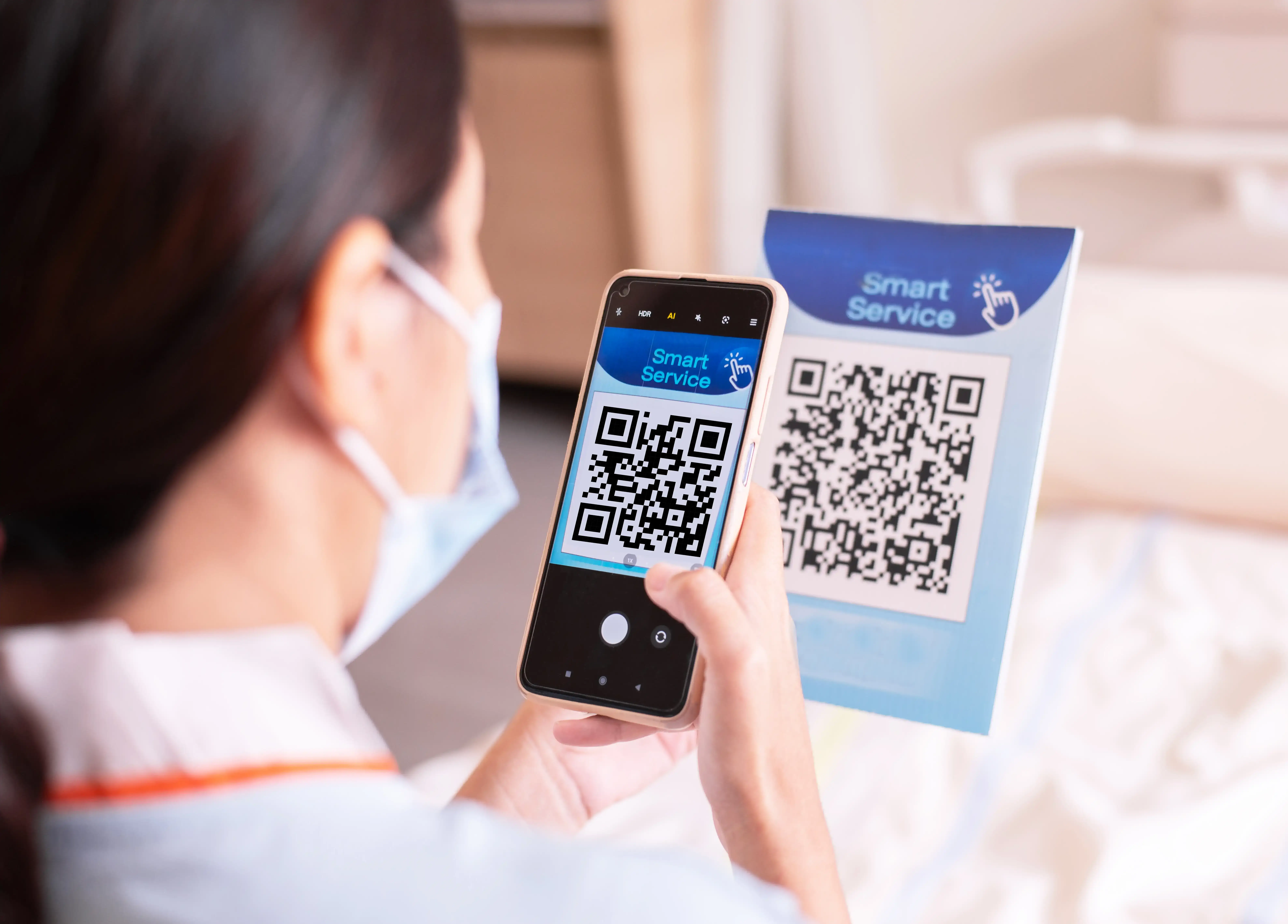 Person in white shirt scanning Smart Service QR code on blue display card with smartphone camera app for contactless service access and digital customer interaction
